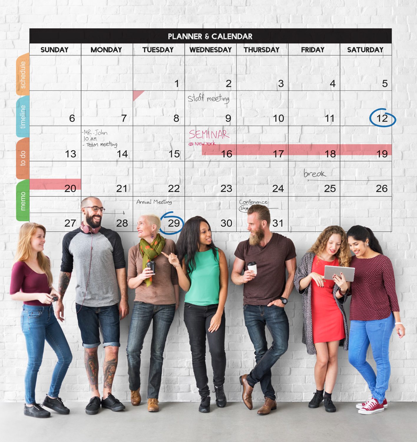 A group of people creating a personalized community calendar filled with shared memories and photos.